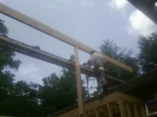 Carpenter setting a ridge beam over a new addition frame — Ice Dam Removal by Roofing Brothers in Black Lick