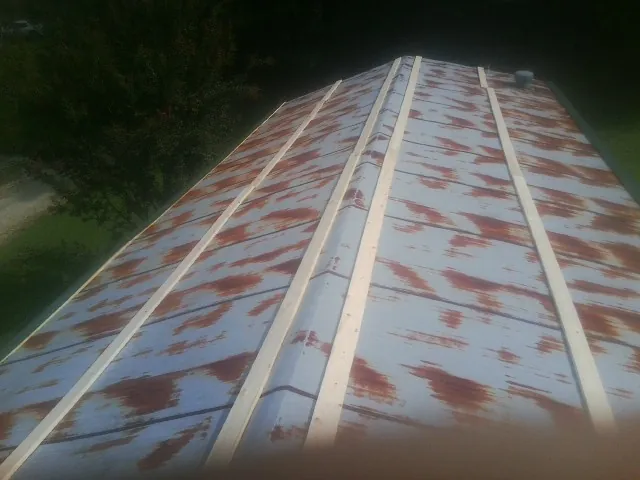 Rusted metal roof panels with new wood purlins before replacement — Storm Damage Roof Repair in Black Lick by Roofing Brothers