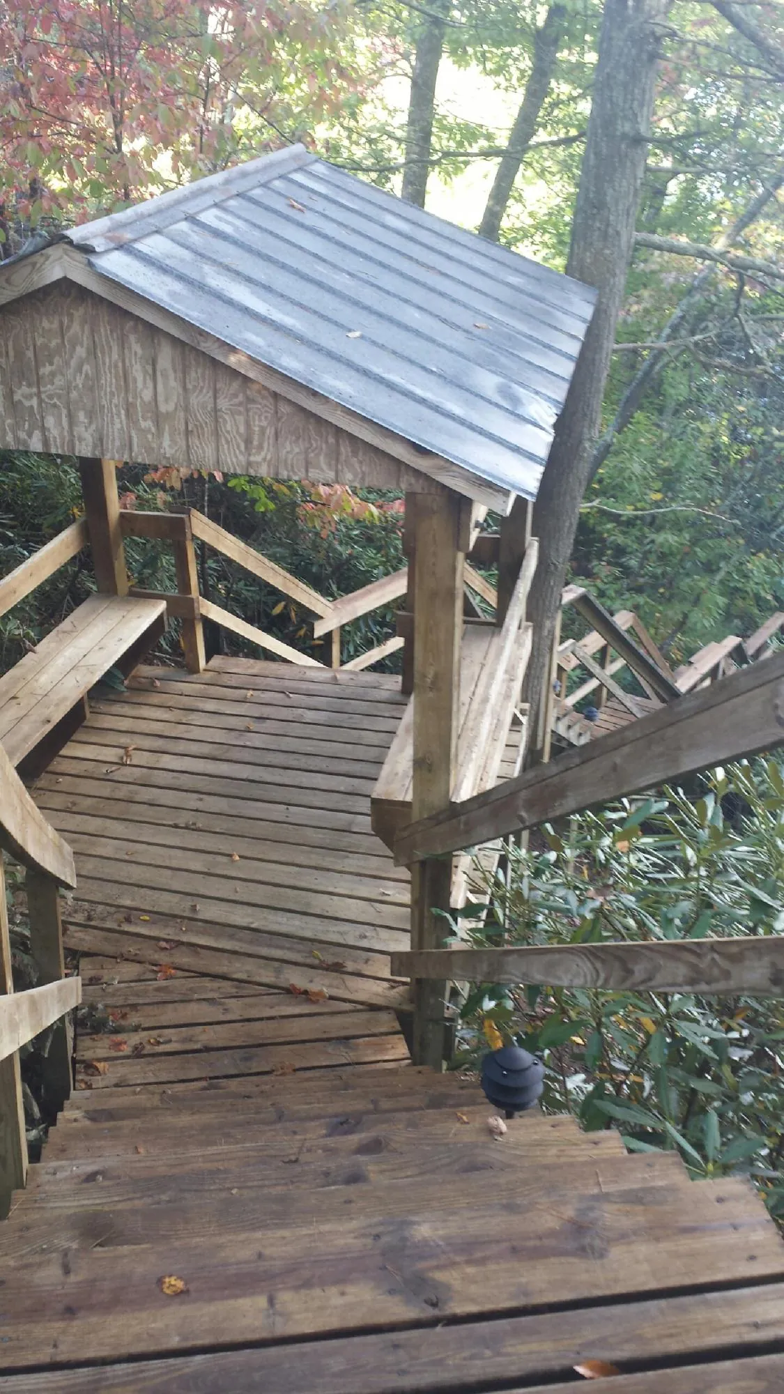Metal roofed shelter over wooden steps on a wooded walkway — Skylight Repair & Installation work by our crew in Black Lick