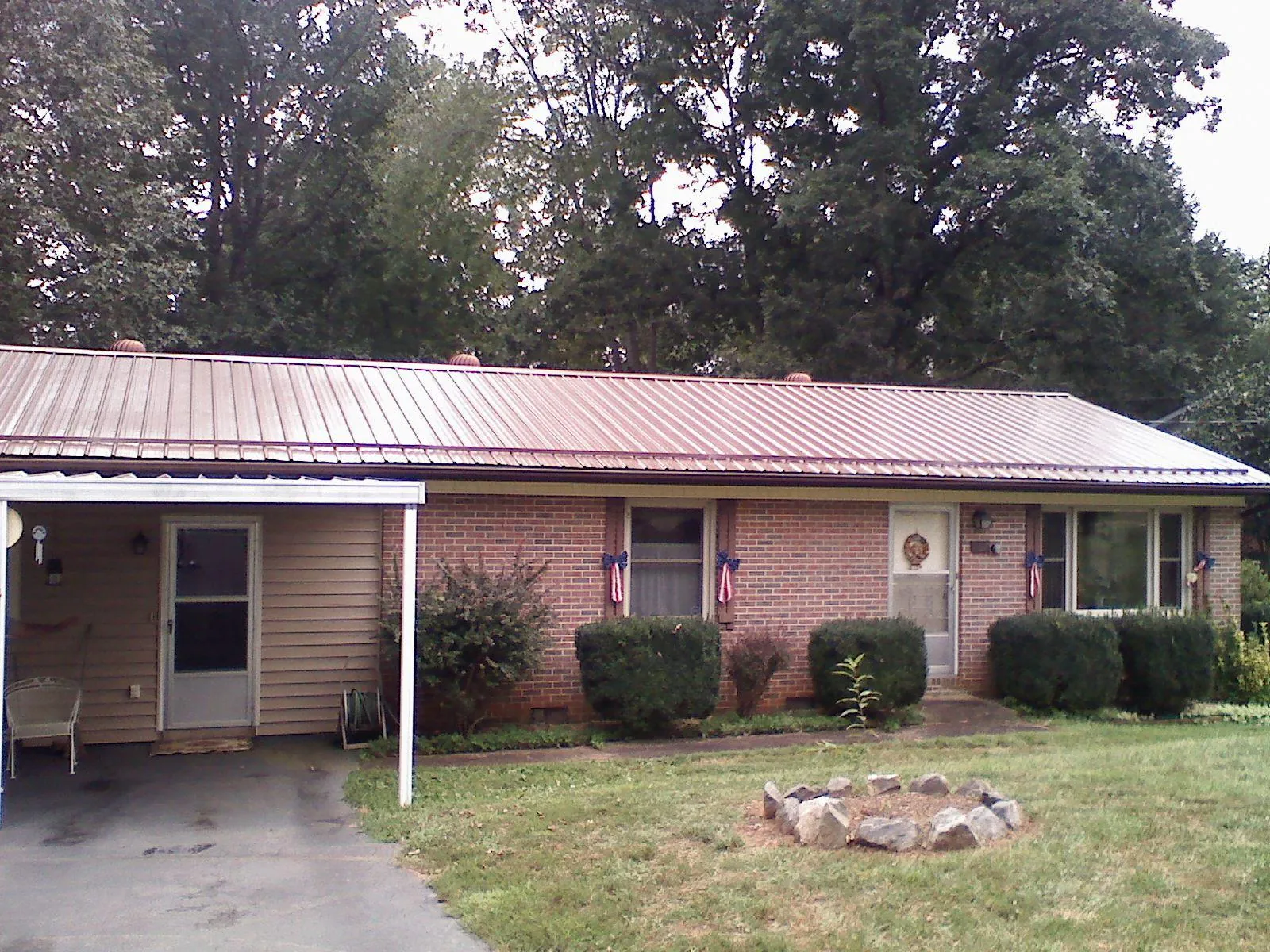 Bronze metal roof and carport on a brick ranch home — Roof Repair work by our crew in Black Lick